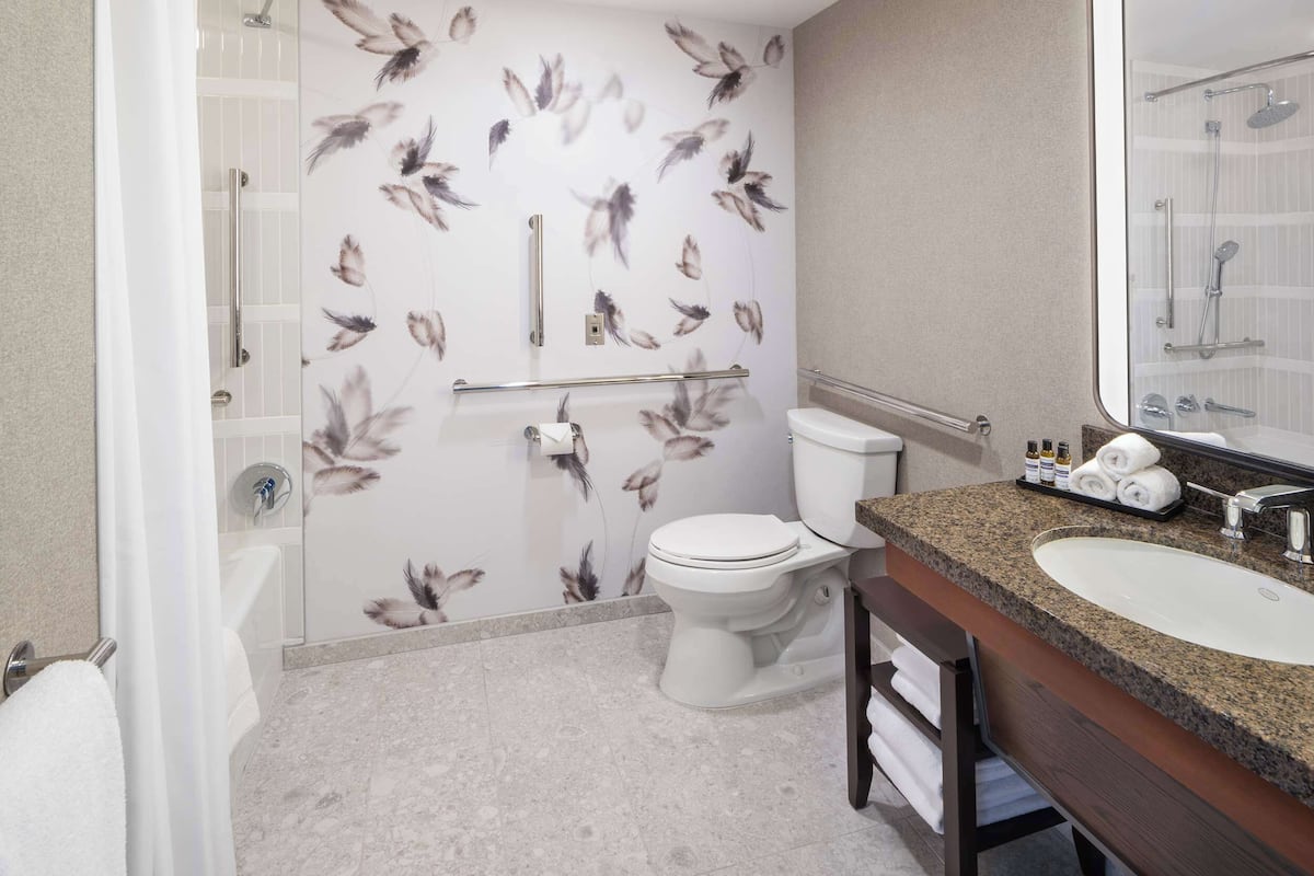 Une salle de bain avec des toilettes, un lavabo et une douche.
