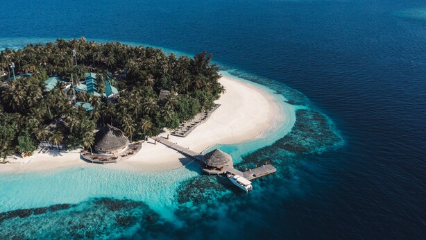 An aerial view of a tropical island resort with a white sandy beach, clear turquoise waters, and lush greenery. - Dhawa Ihuru, part of Banyan Group – All inclusive with Free Transfer (Ihuru)
