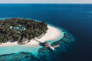 An aerial view of a tropical island resort with a white sandy beach, clear turquoise waters, and lush greenery. - Dhawa Ihuru, part of Banyan Group – All inclusive with Free Transfer (Ihuru)