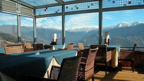 A dining area with a view of snow-capped mountains through large windows. - Dream Town (Ren'ai)