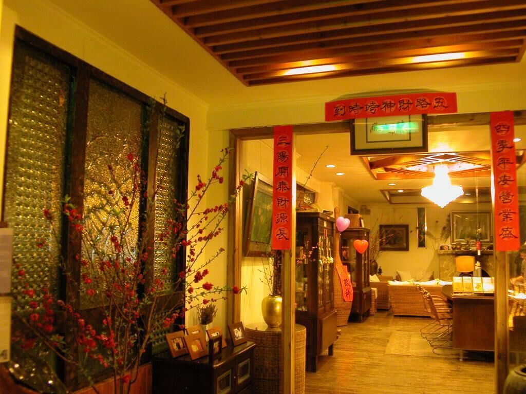 A traditional Japanese interior with wooden beams, a reception desk, and red banners.
