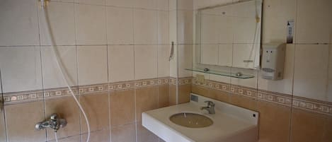 Un baño con lavamanos, espejo y ducha.