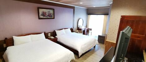 Habitación de hotel con dos camas, techo de madera, un cuadro en la pared, un escritorio con computadora y una ventana con cortinas.