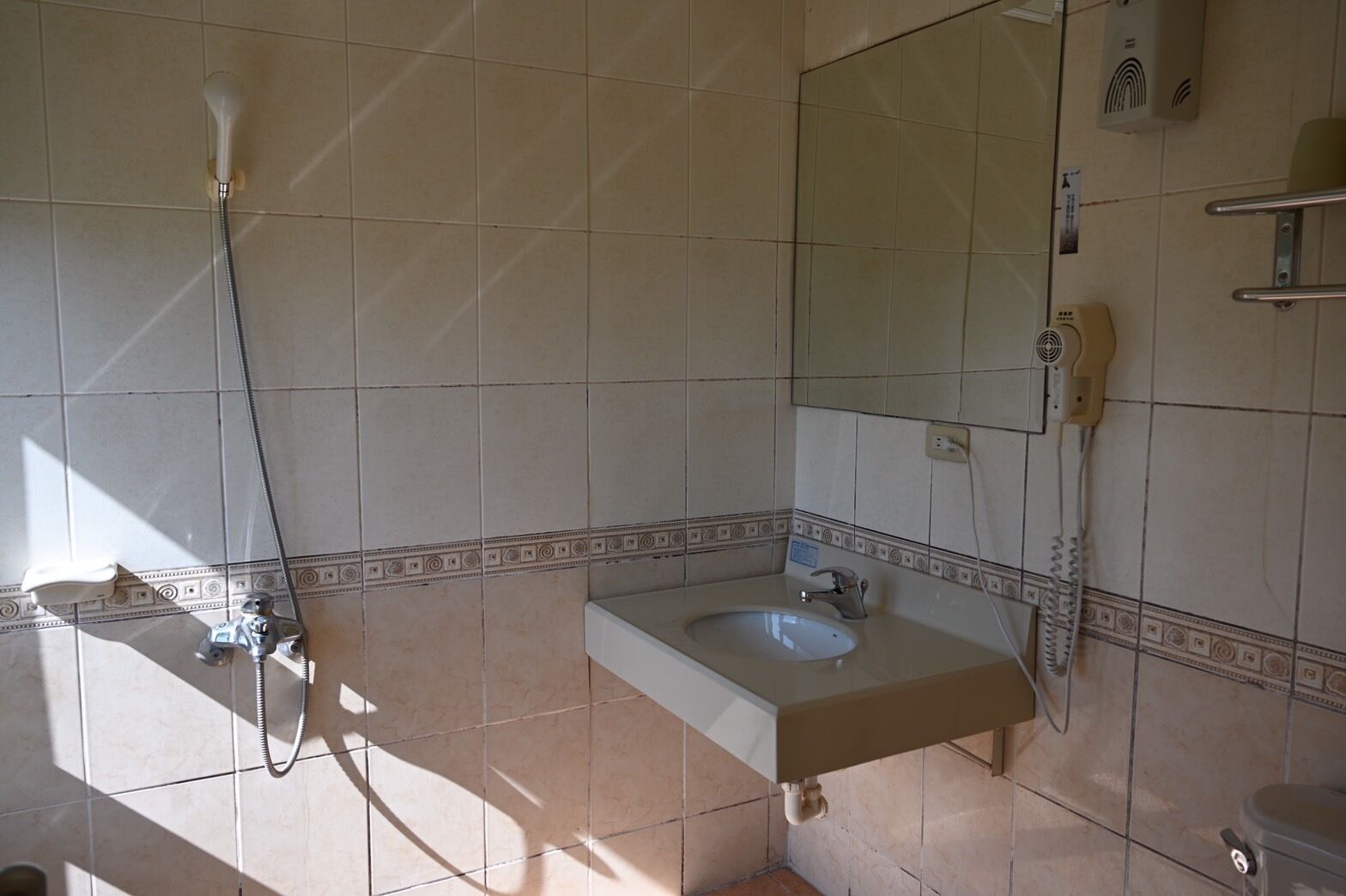 A bathroom with a sink, mirror, and shower.