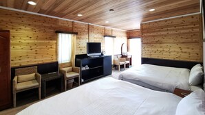A wooden-paneled room with two beds, a TV, and a small seating area. - Dream Town (Ren'ai)