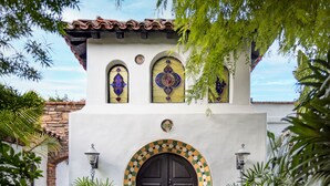 A building with a black door, two arched windows, and a tiled roof. - Lucille Palm Springs (Palm Springs)