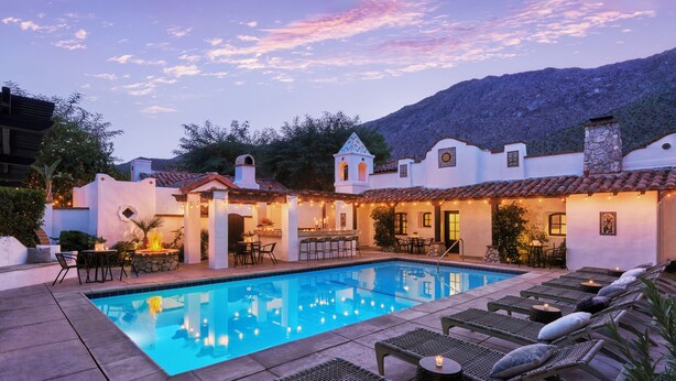 A poolside area with lounge chairs, a bar, and outdoor seating. - Lucille Palm Springs (Palm Springs)