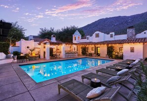 A poolside area with lounge chairs, a bar, and outdoor seating.