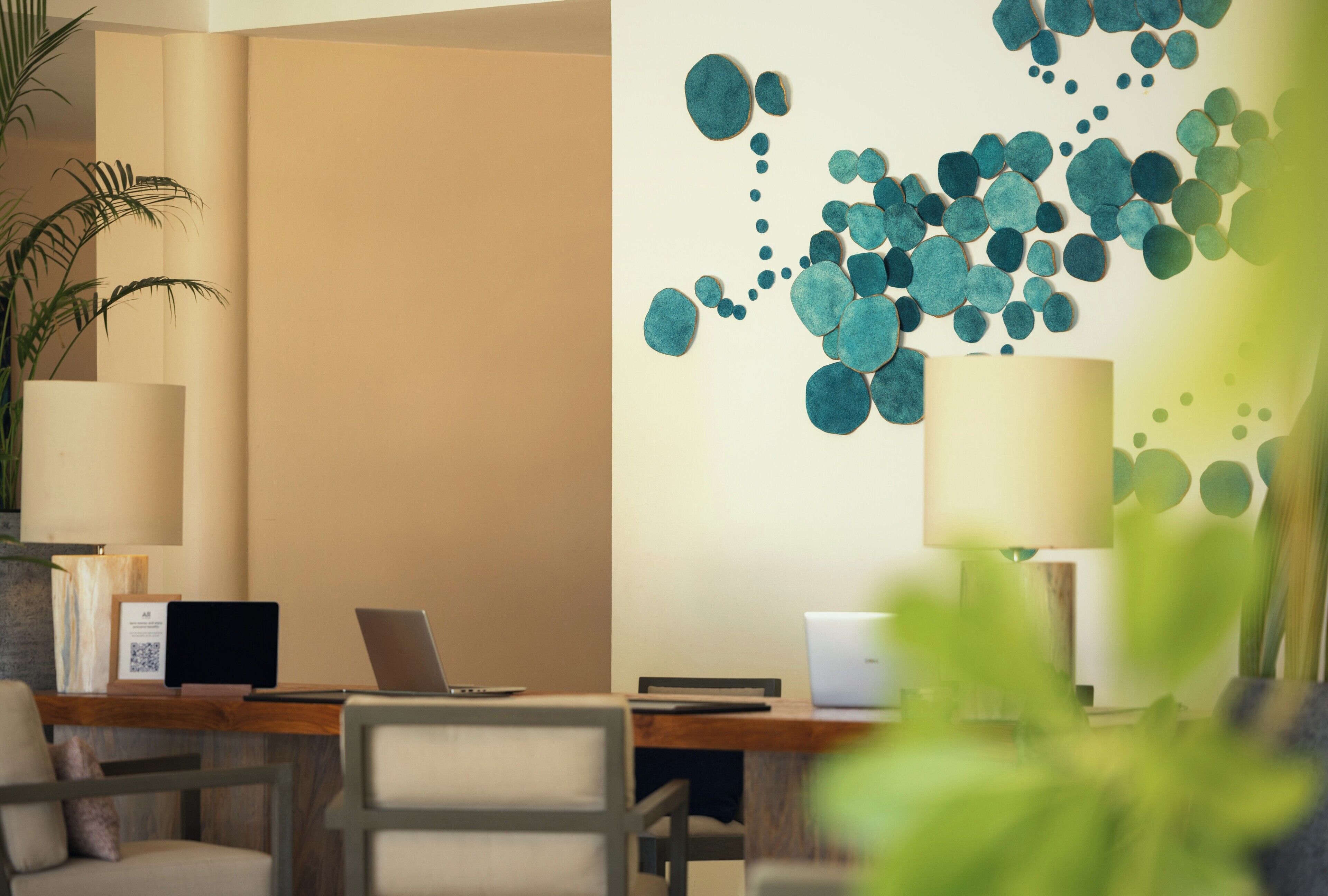 Un espacio de oficina moderno con un escritorio, sillas y una pared decorativa.