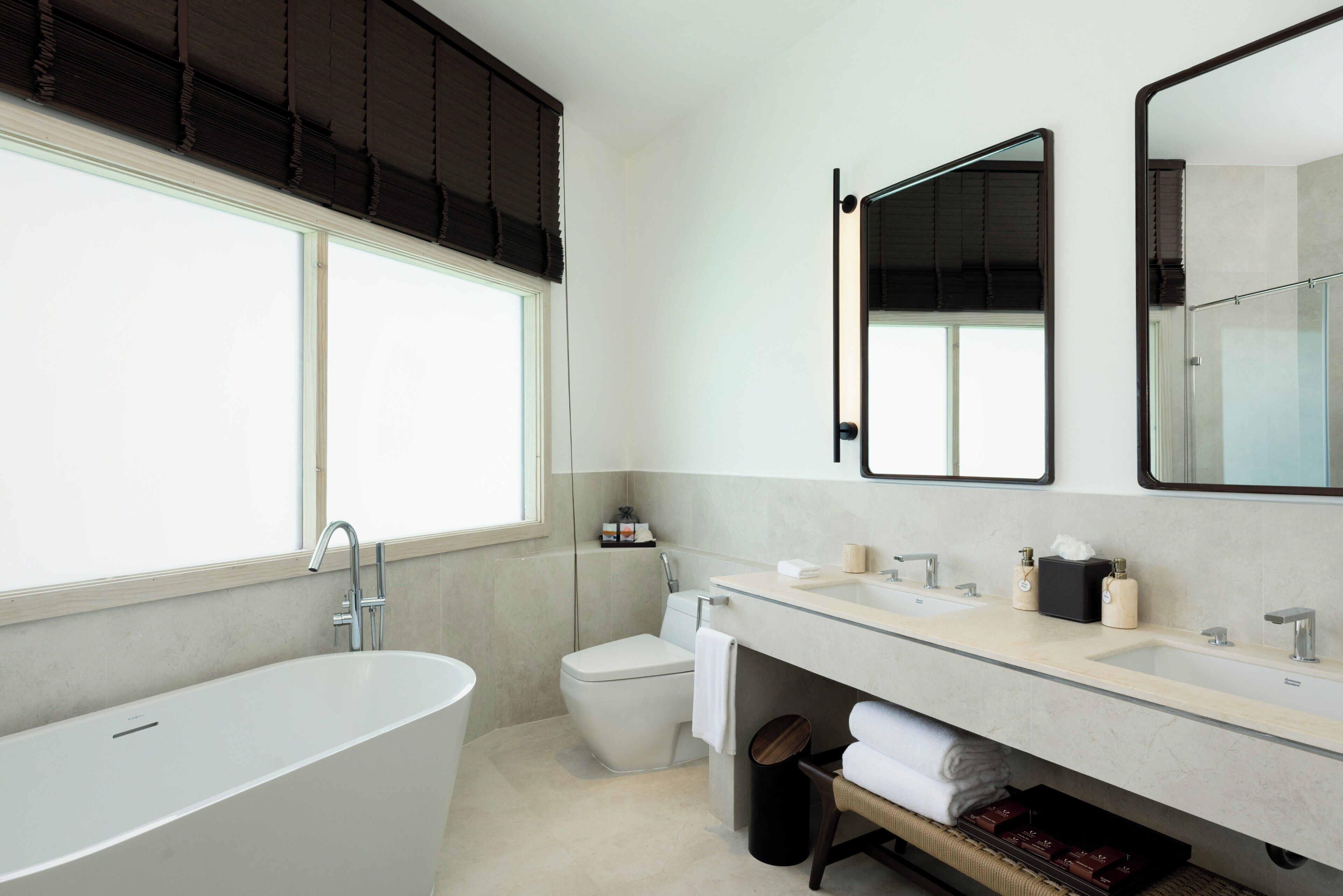 Un baño moderno con una bañera independiente, un inodoro y un tocador con espejo.