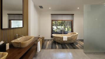 A modern bathroom with a freestanding bathtub, a wooden vanity, and a large mirror.