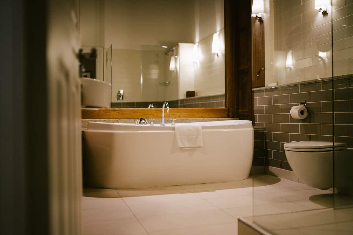 deluxe room | bathroom | combined shower/bathtub, designer toiletries, hair dryer, bathrobes