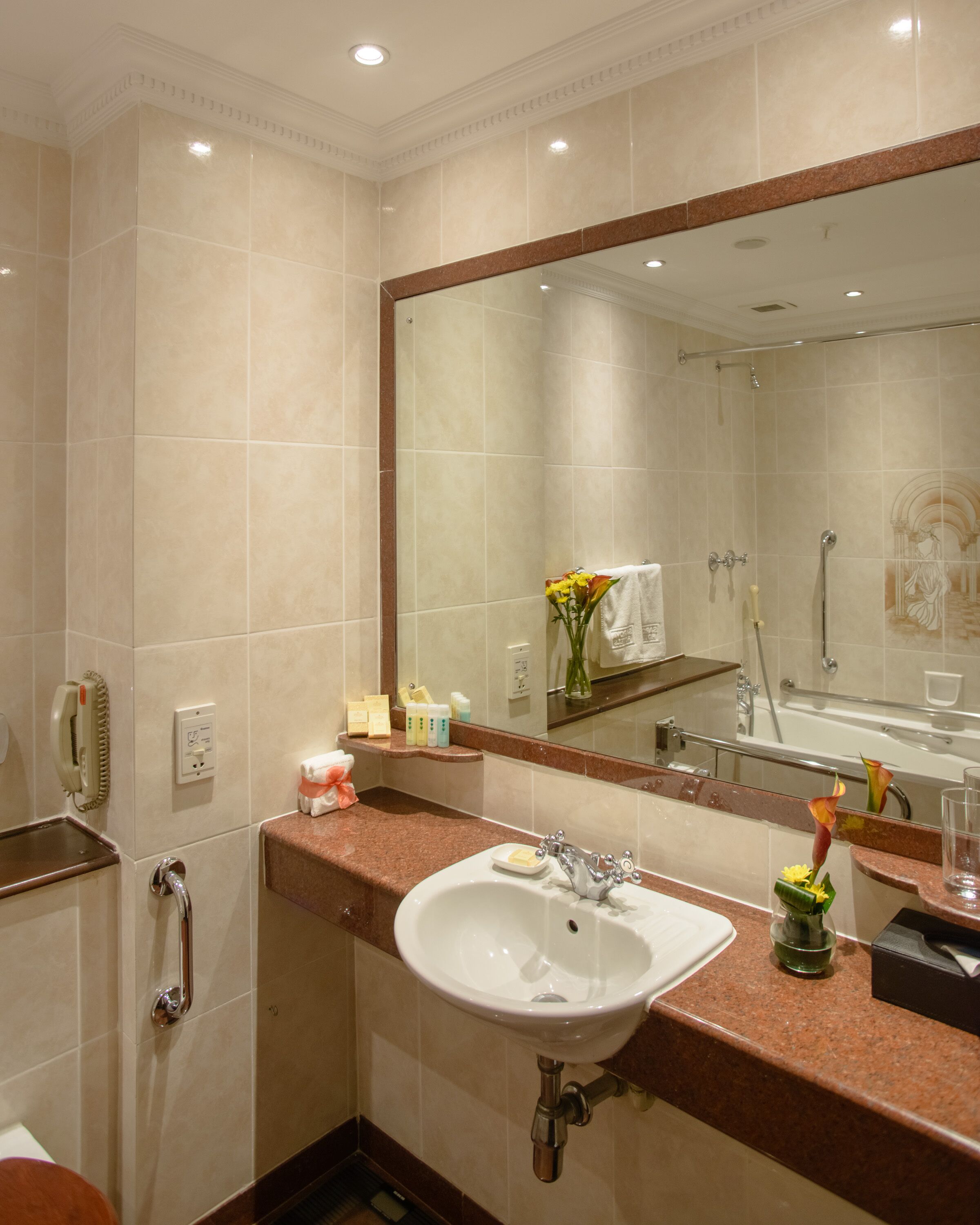 Un bagno con uno specchio grande, un lavandino, una doccia e un water.