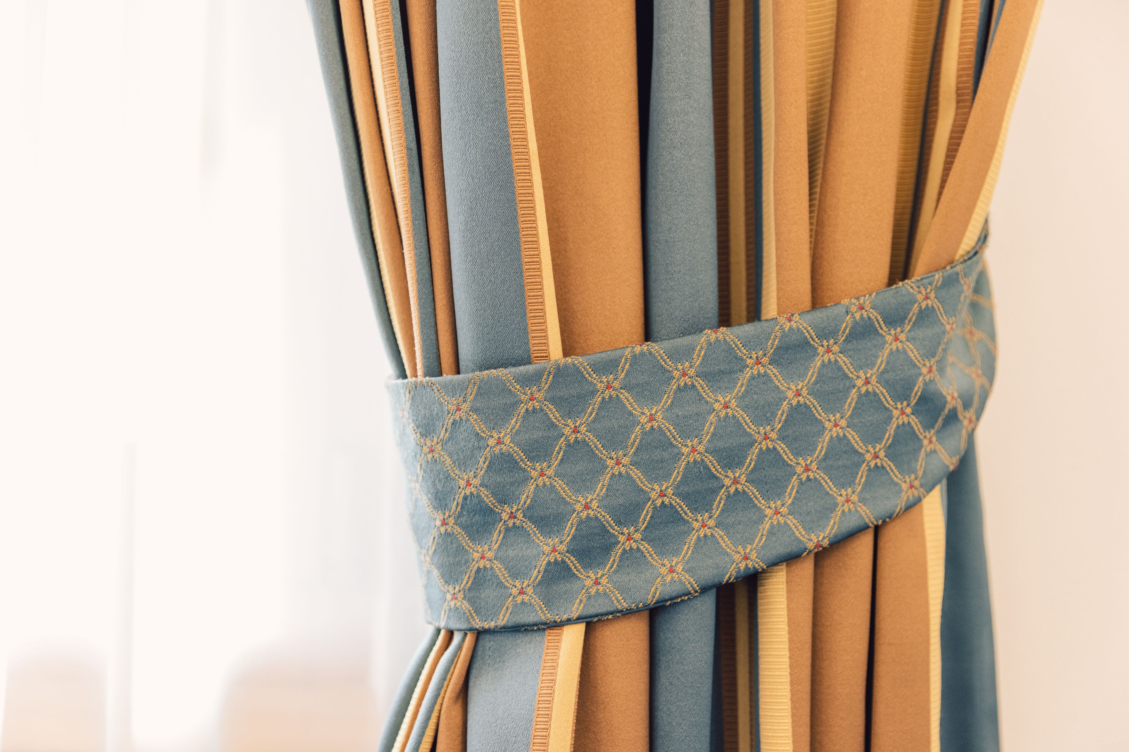 A close-up of a curtain with a geometric pattern and a blue and gold color scheme.