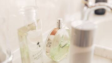 Un meuble-lavabo de salle de bain avec trois flacons de parfum.