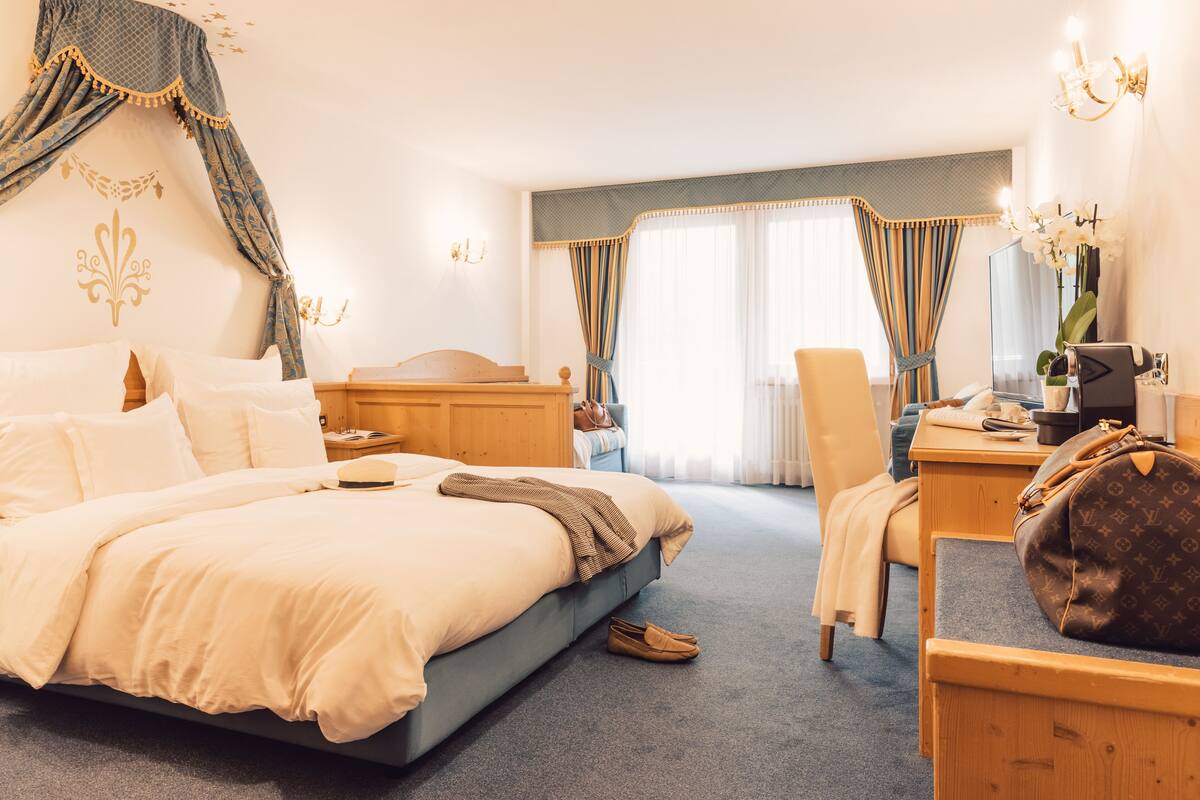 Een hotelkamer met een groot bed, een bureau, een stoel en een kledingkast.