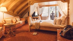 Une chambre confortable avec un lit à baldaquin, un canapé, une petite table et une chaise.