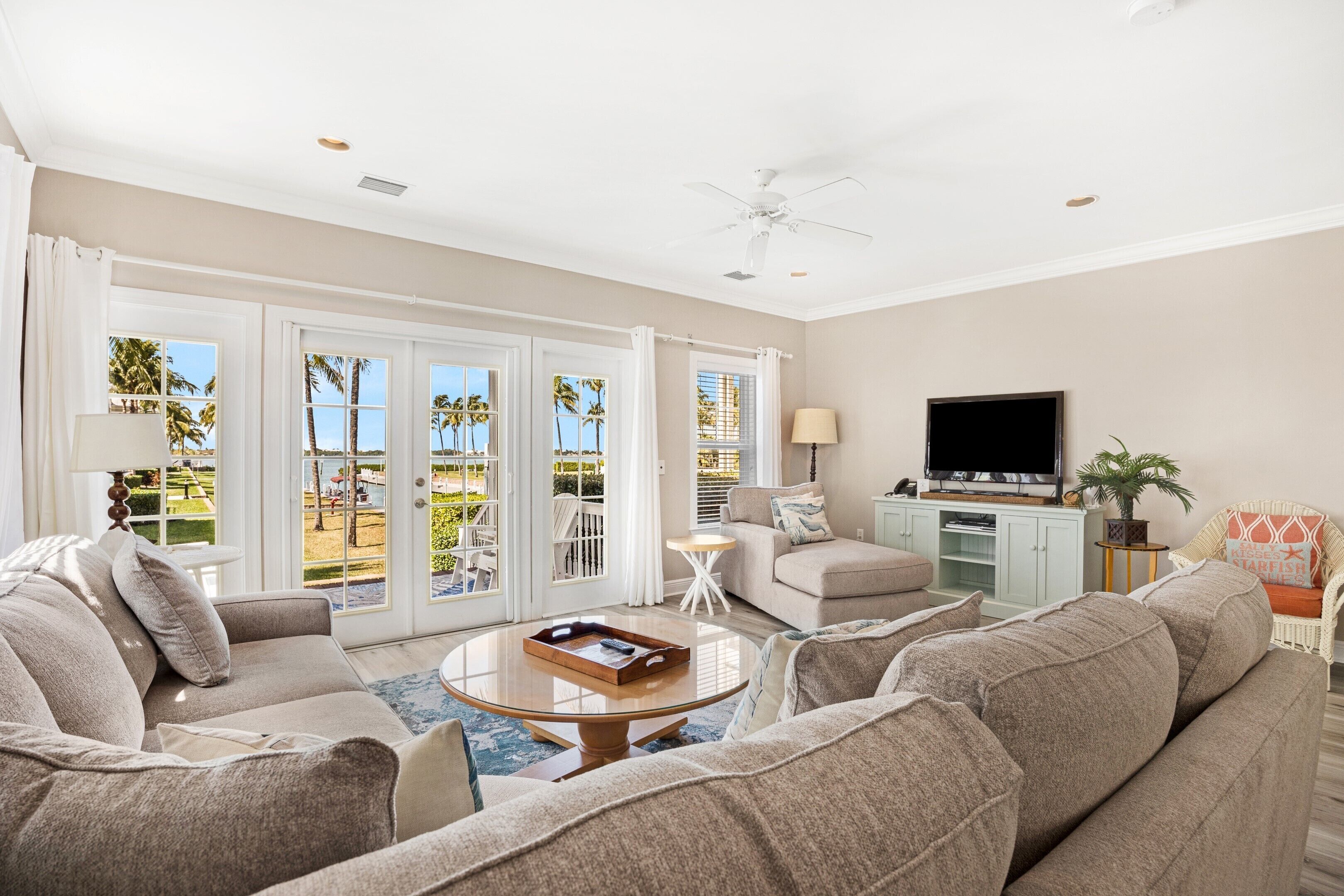 A spacious living room with a large sofa set, a coffee table, and a television on a cabinet.