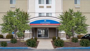 Entrada de um hotel com uma placa que diz 'Candlewood Suites'.