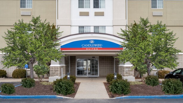 Een hotelingang met een bord waarop 'Candlewood Suites' staat.