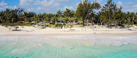 On the beach, white sand, sun-loungers, beach towels