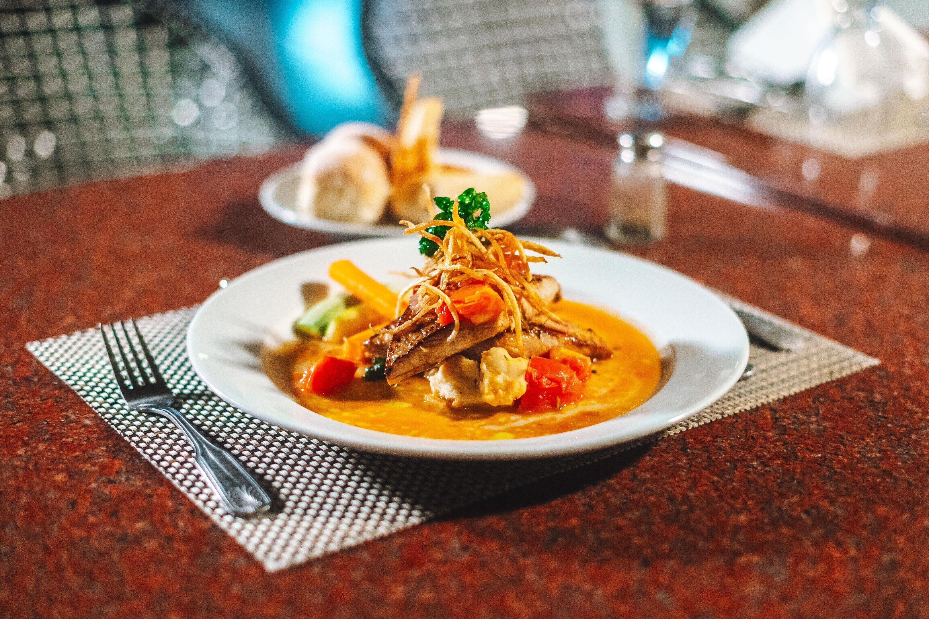 A plate of food with a fork and napkin on a table.