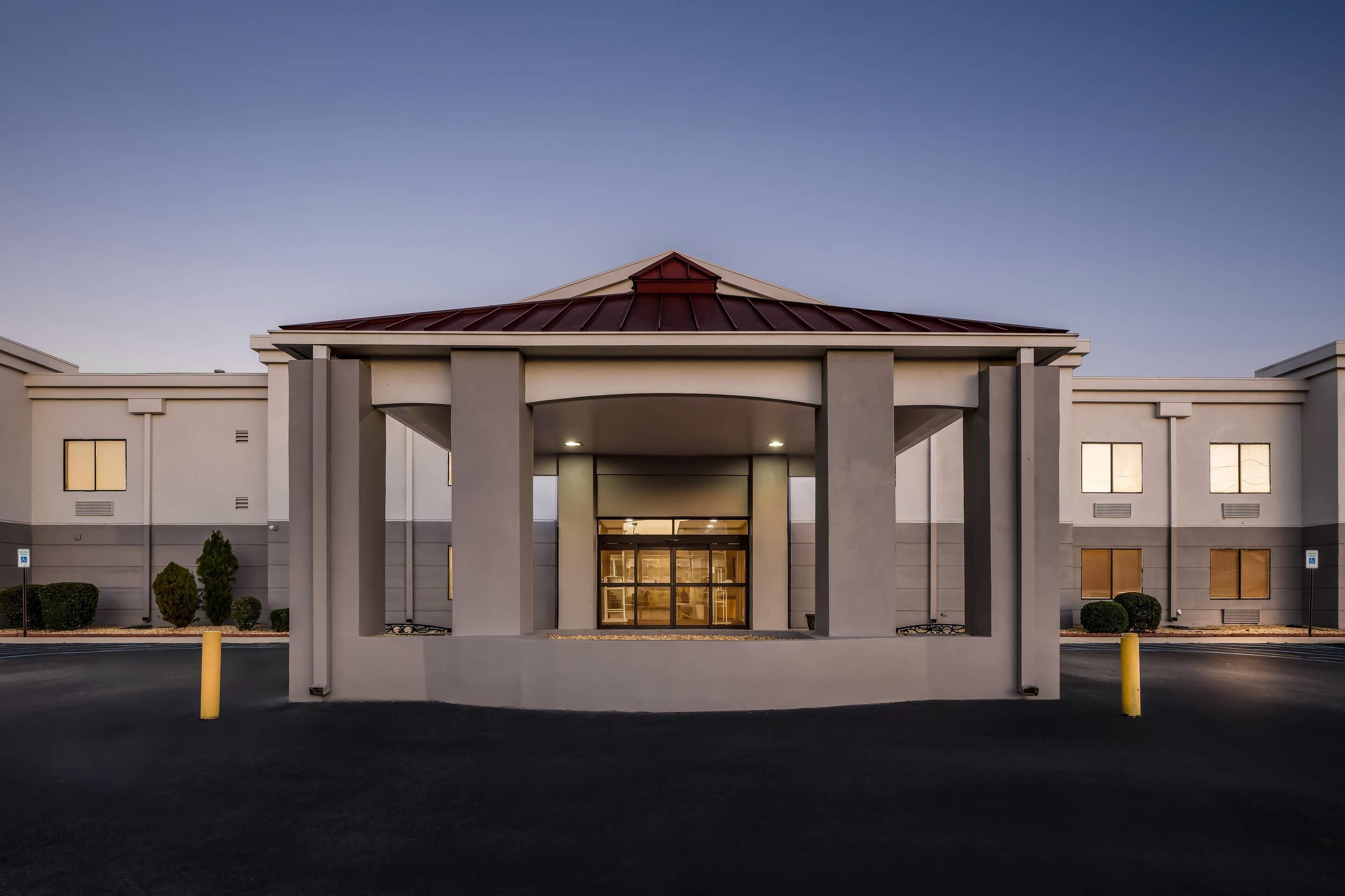 A modern building with a central entrance, large windows, and a symmetrical facade.