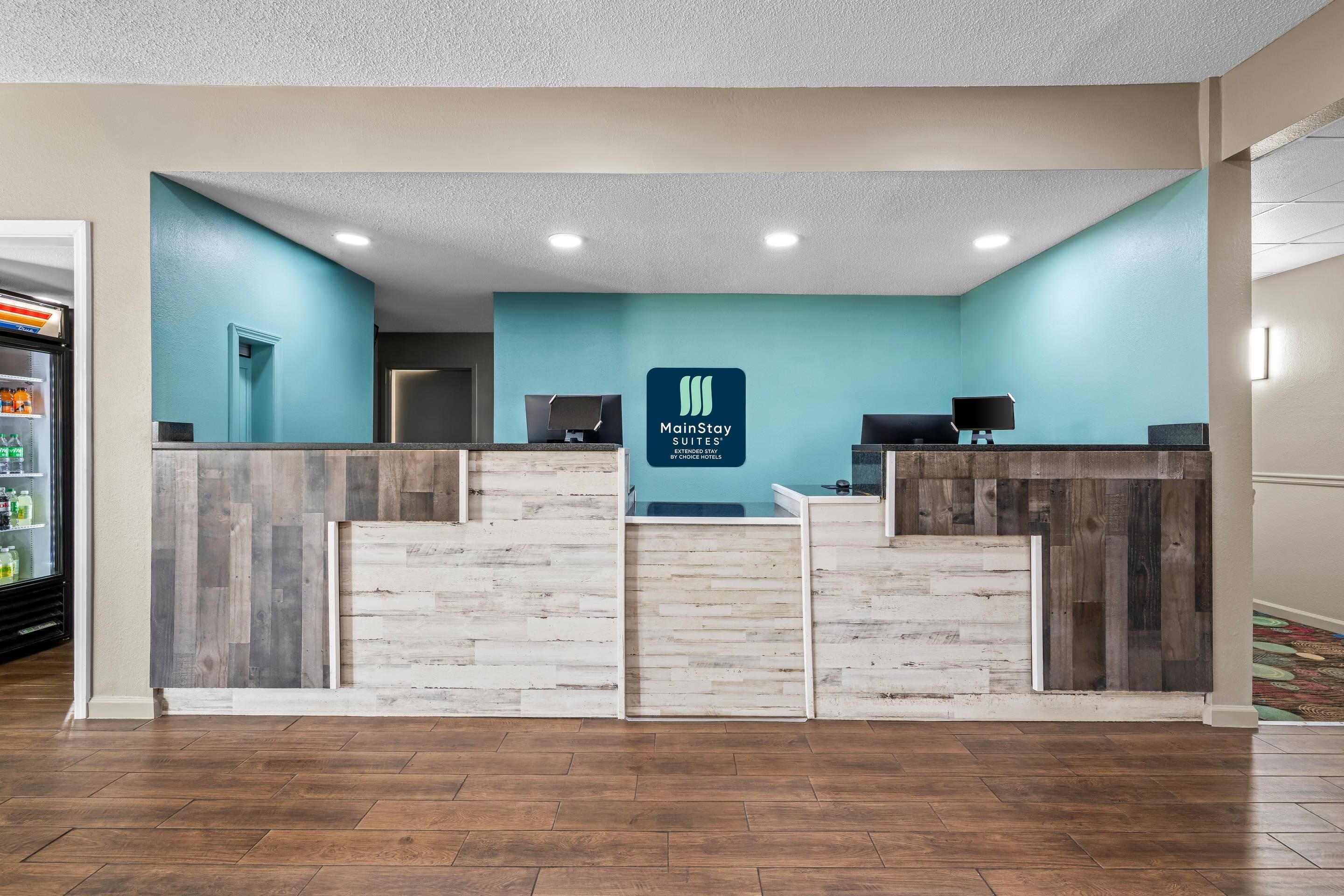 A reception desk with a teal wall and a wooden panel design.