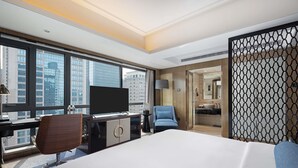 A hotel room with a large bed, a desk with a flat-screen TV, a chair, and a view of the cityscape through large windows. - Pullman Shanghai Jing An (Shanghai)
