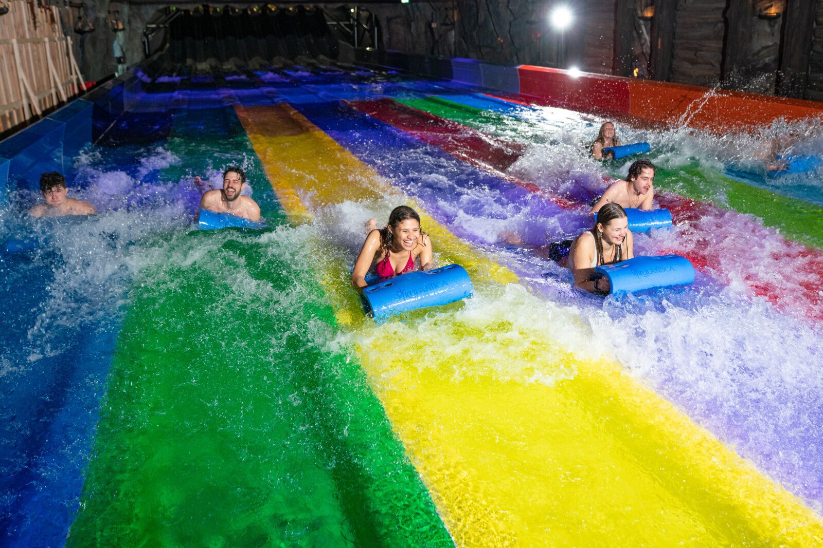 Un toboggan aquatique à plusieurs pistes, chacune étant d’une couleur différente.