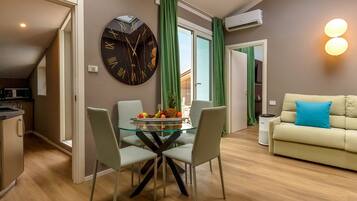 Un apartamento moderno con tragaluces, un comedor con mesa de vidrio y una sala de estar con sofá.