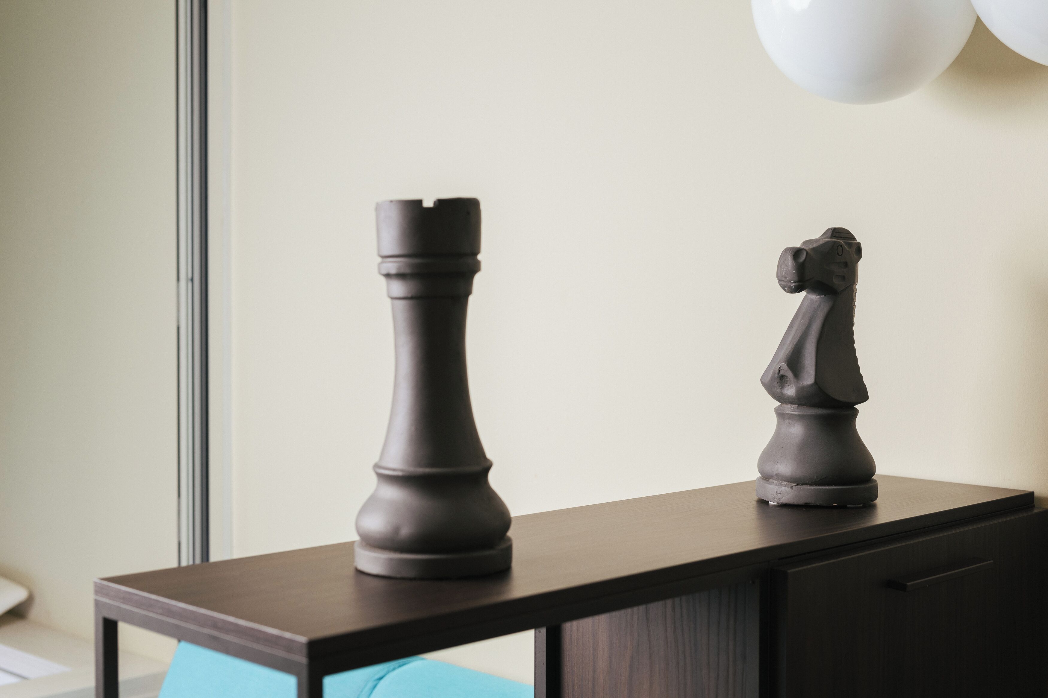 A table with two chess pieces on a dark wooden surface.