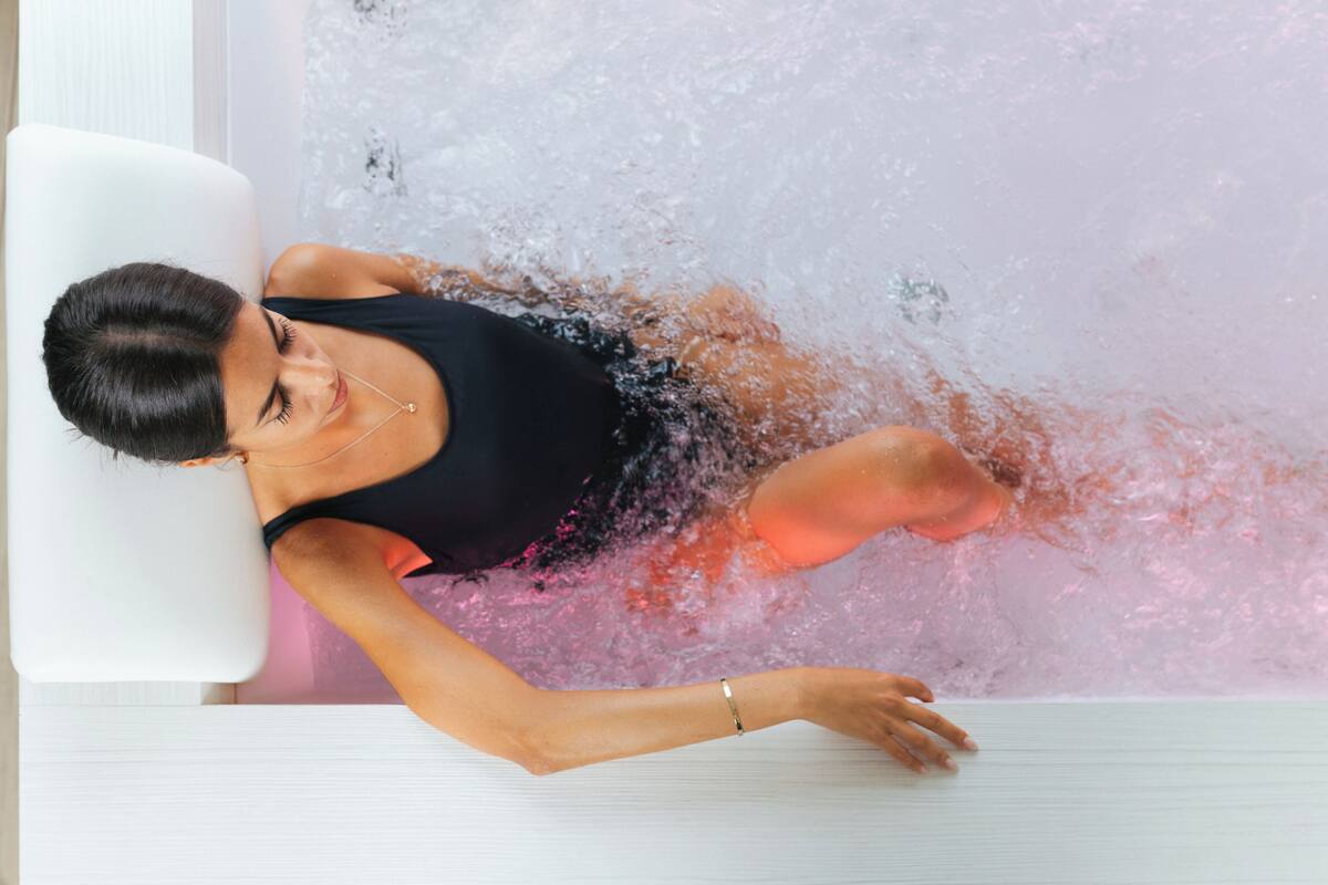 A person reclining in a bathtub filled with water.