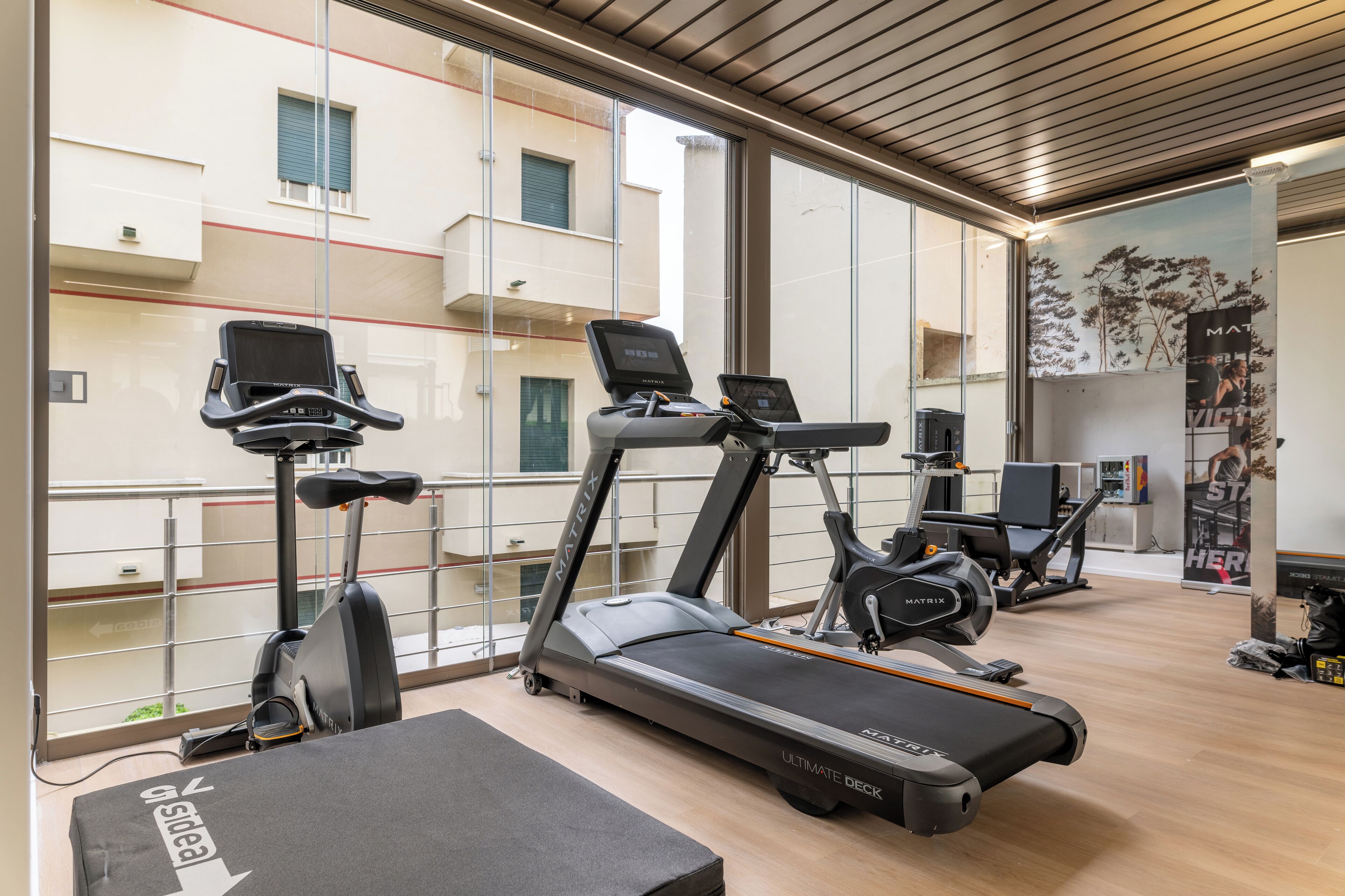 A modern gym with treadmills, elliptical machines, and a rowing machine.
