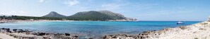 A coastal landscape with rocky terrain, clear turquoise waters, and a boat in the distance. - Hotel & Spa S'entrador Playa (Capdepera)