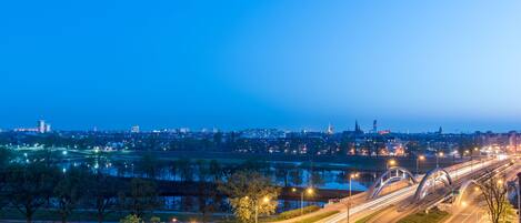 A nighttime cityscape with illuminated roads and distant buildings.