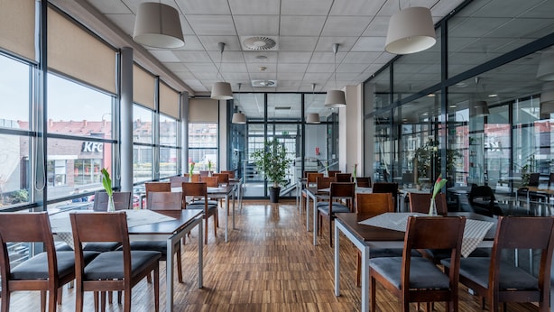 A spacious indoor dining area with wooden flooring, large windows, and modern pendant lighting. - Weiser Hotel (Wroclaw)