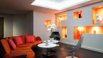 Una sala de estar moderna con un sofá modular, una mesa de centro redonda y una silla original.