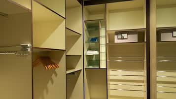A walk-in closet with multiple shelves and hanging space, a dark carpeted floor, and recessed ceiling lighting.