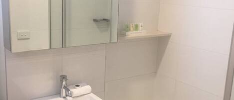 A bathroom with a glass shower enclosure, a white sink, and a bathtub.