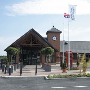 A hotel entrance with a clock tower, a British flag, and a red telephone booth. - Morley Hayes Hotel (Ilkeston)