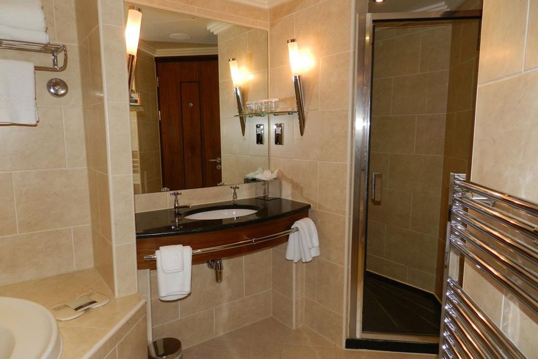 A modern bathroom with a sink, mirror, and shower.