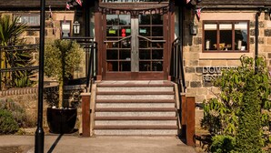 Un pub tradicional con un letrero que dice "The Dovecote The Dovecote" y fachada de piedra.