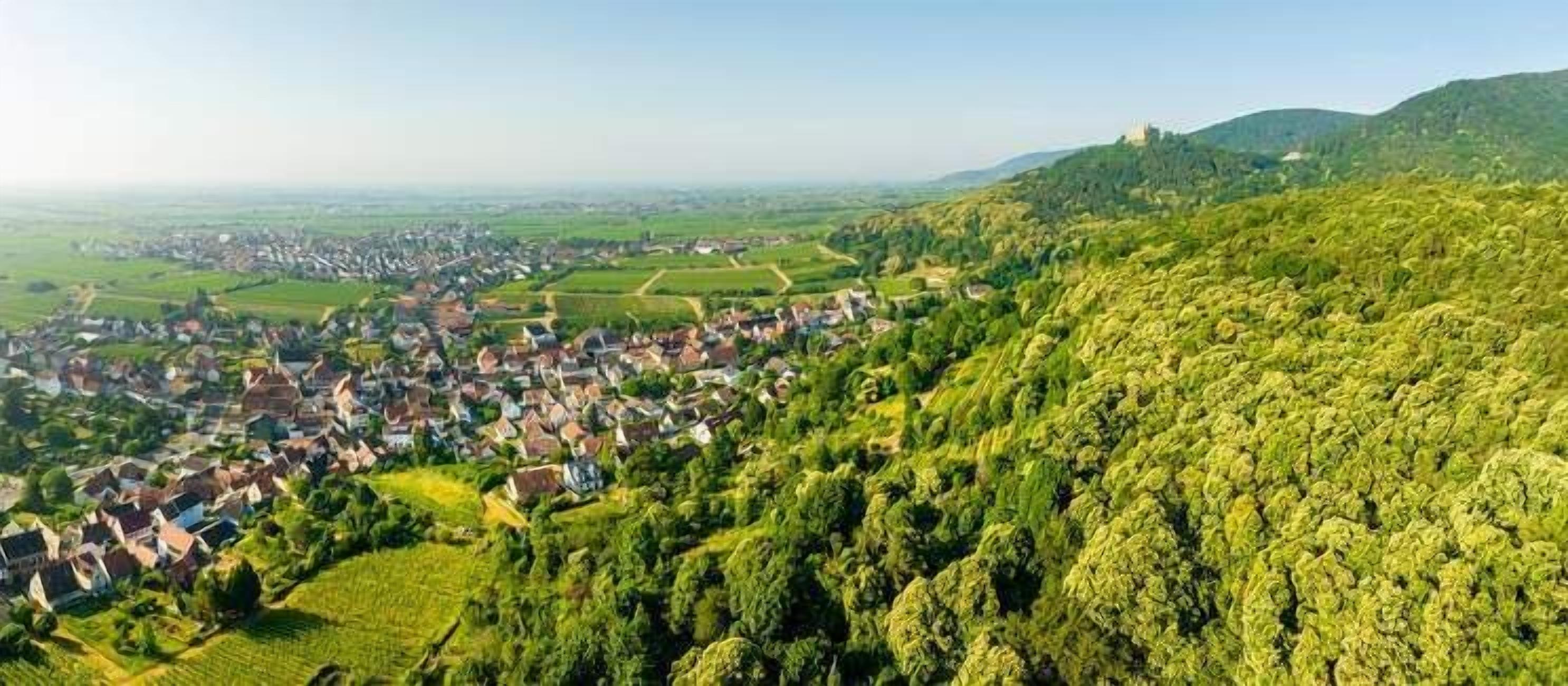 Une ville nichée dans une vallée, avec une colline imposante en arrière-plan.