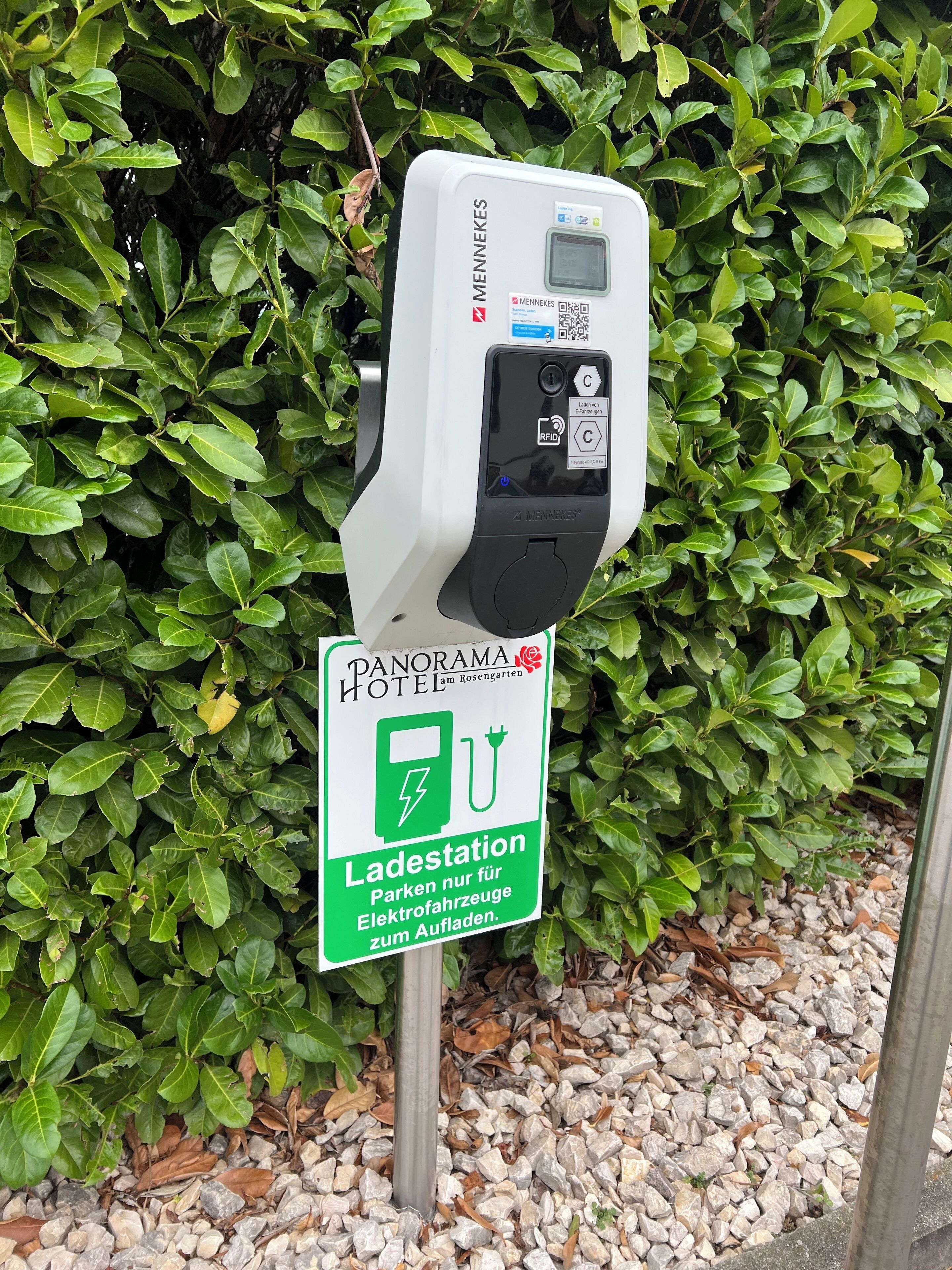 Un parcmètre avec un panneau indiquant qu’il s’agit d’une borne de recharge pour véhicules électriques, situé à l’hôtel Panorama.