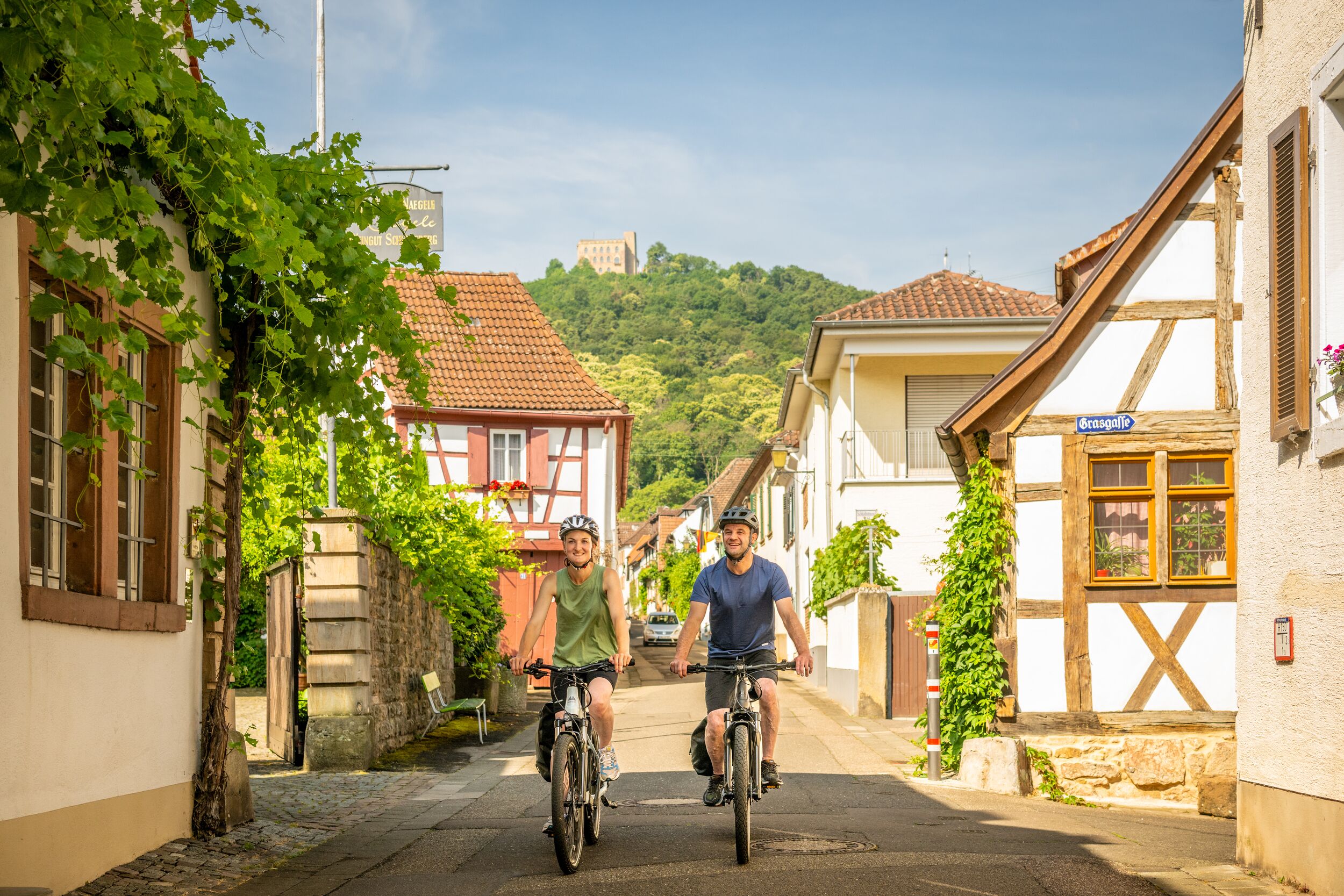 Une rue étroite, bordée de bâtiments des deux côtés, un mur de pierre et une enseigne indiquant « Orsaglia ».