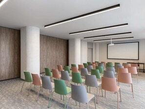 A conference room with rows of chairs, a projector screen, and modern lighting. - Mercure Sofia City  (Sofia)