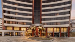 A modern hotel with a curved facade, multiple floors, and a central entrance with a canopy. - Mercure Sofia City  (Sofia)