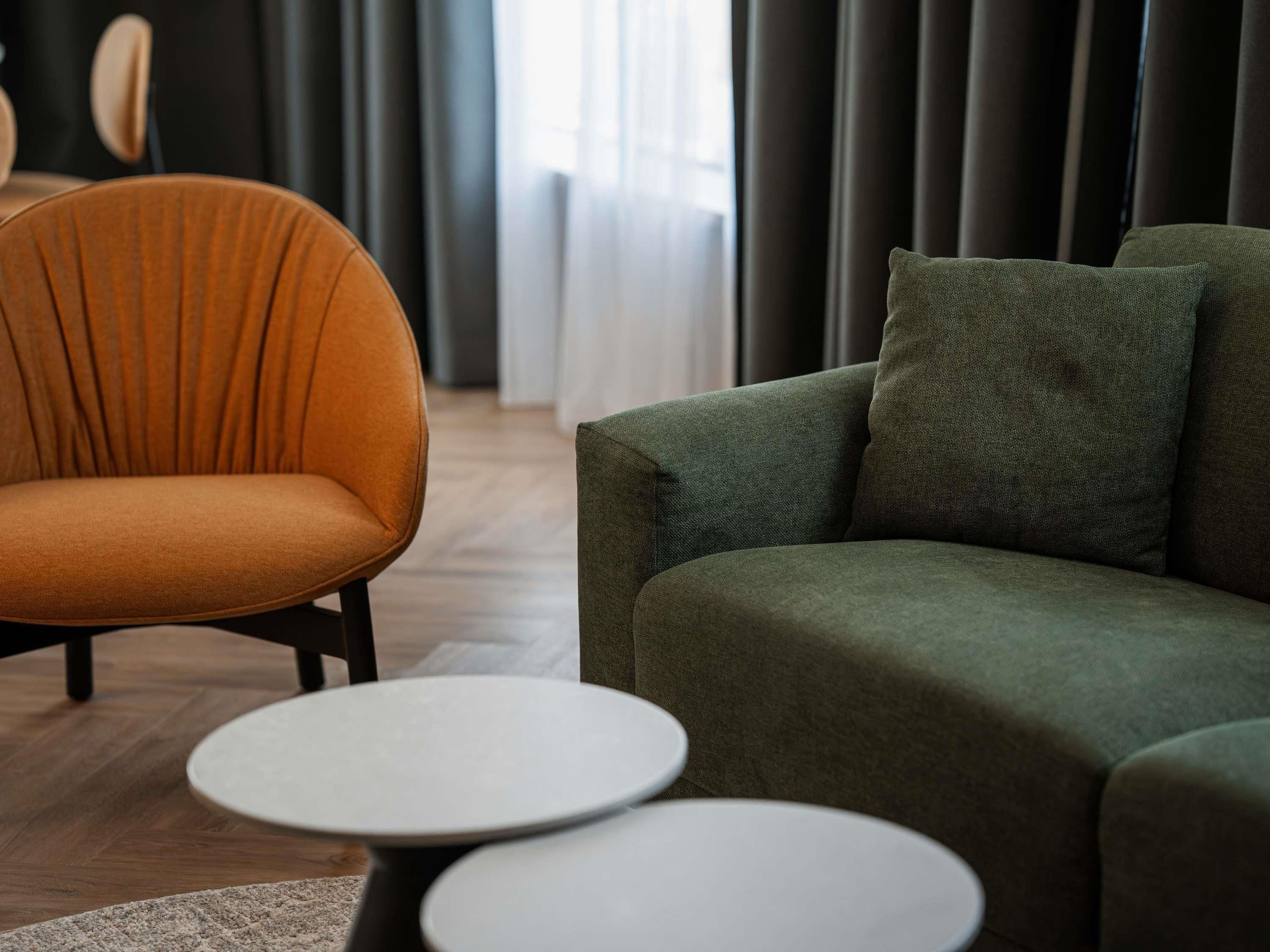 A modern living room with a sofa, a chair, and two round tables.