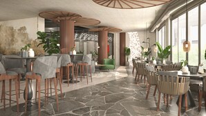 A modern interior with a mix of seating areas, including tables and chairs, and a stone-tiled floor. - Mercure Sofia City  (Sofia)